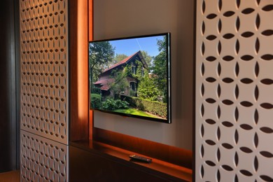 Image of TV set with beautiful house on screen in room