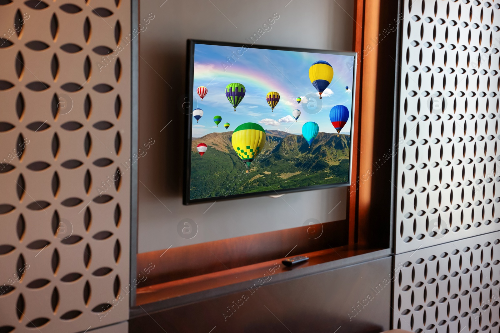 Image of TV set with hot air balloons floating over mountains on screen in room