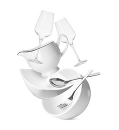 Clean dishware, glasses and silverware flying on white background