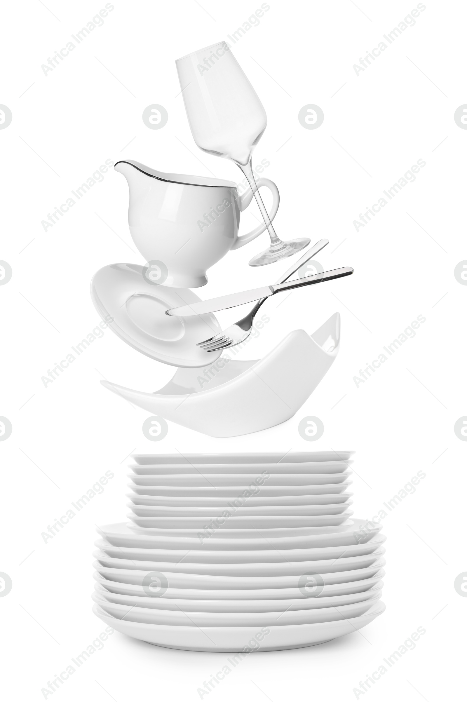 Image of Clean dishware, glass and silverware flying over plates on white background