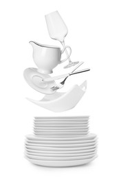 Image of Clean dishware, glass and silverware flying over plates on white background