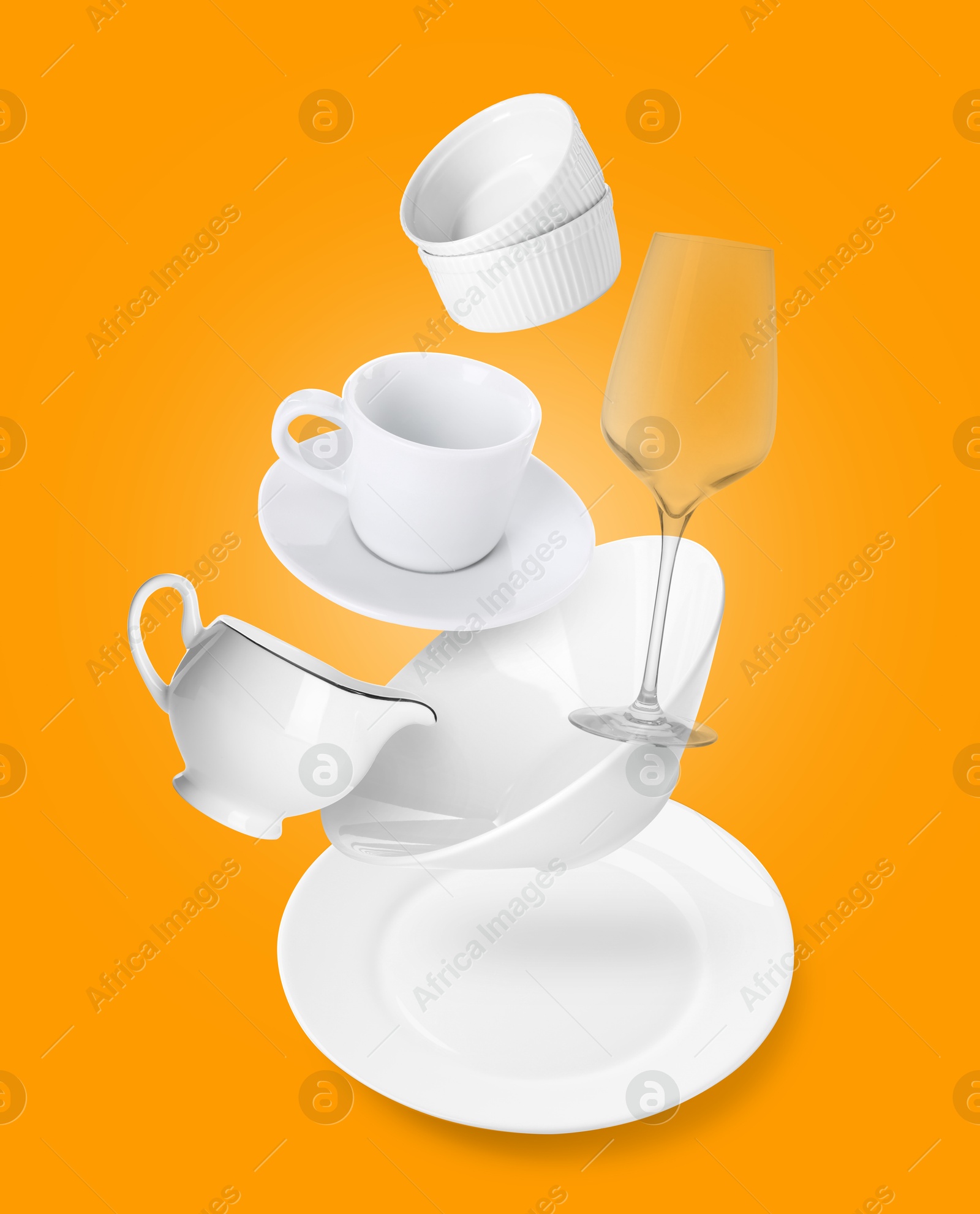 Image of Clean dishware and silverware flying over napkin on orange background