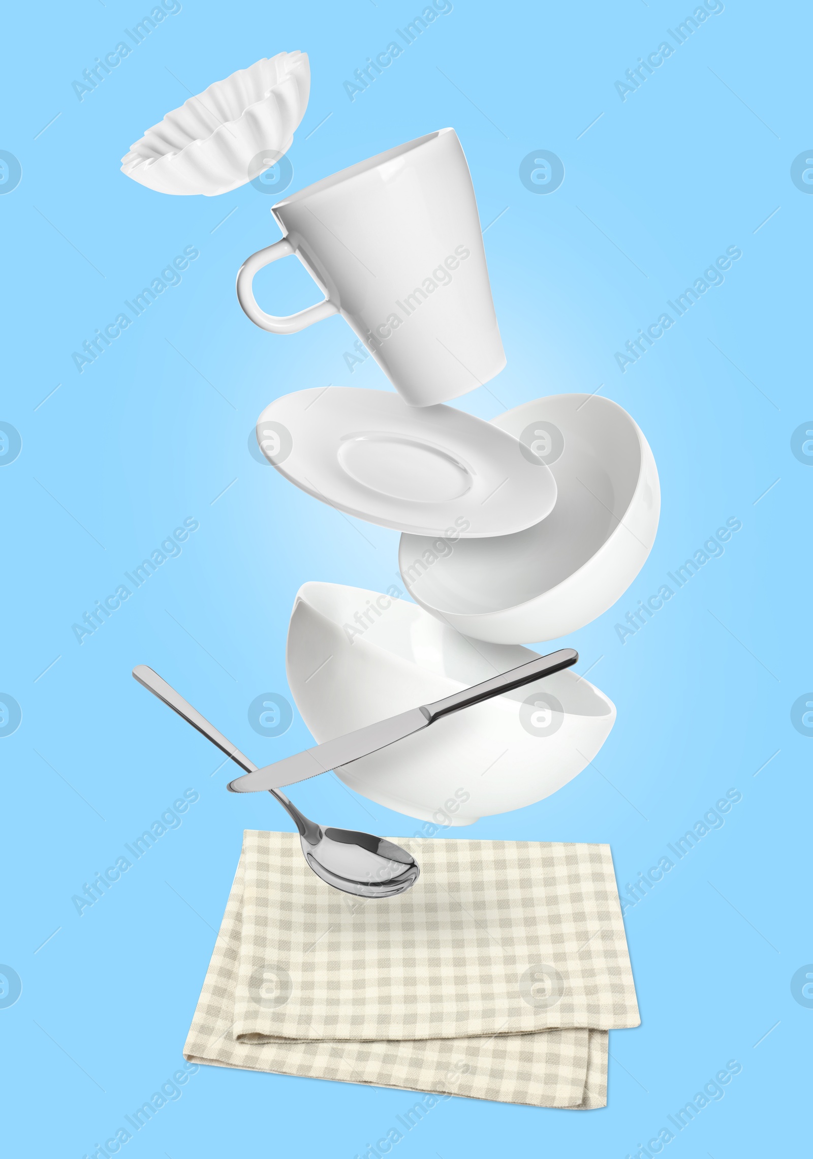 Image of Clean dishware and silverware flying over checkered napkin on light blue background