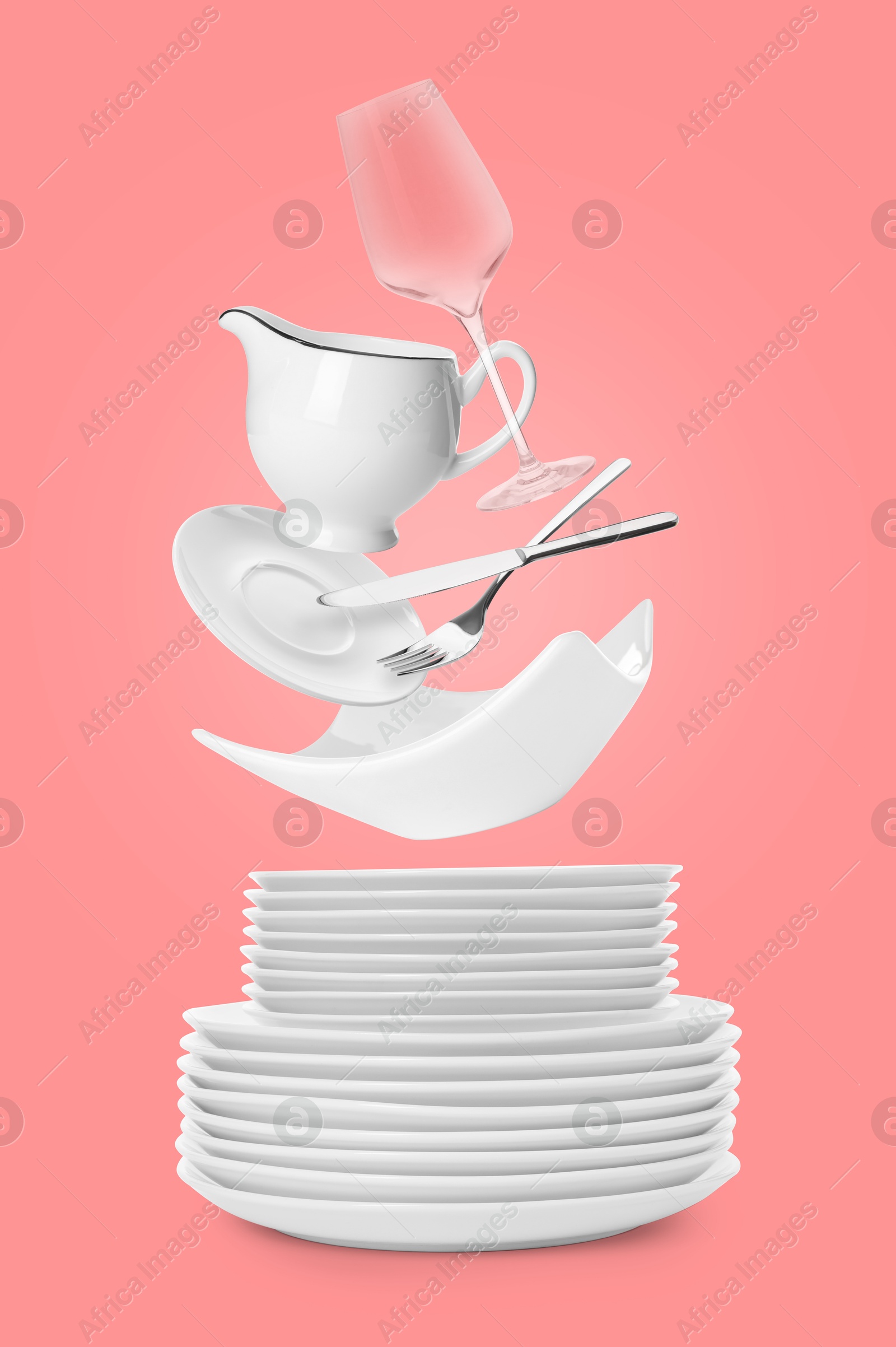 Image of Clean dishware, glass and silverware flying over plates on pink background