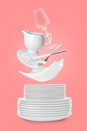 Clean dishware, glass and silverware flying over plates on pink background