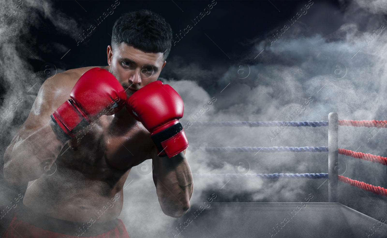 Image of Boxer fighting on boxing ring in smoke. Space for text