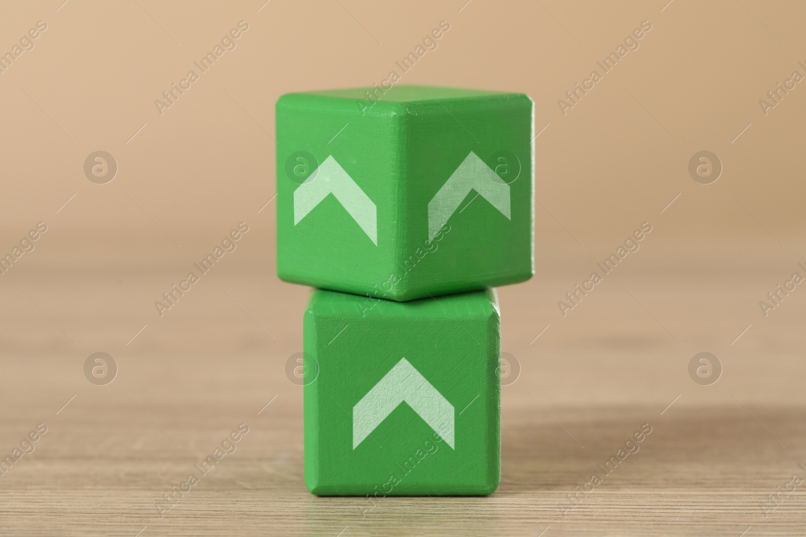 Image of Green cubes with arrows on wooden table, closeup