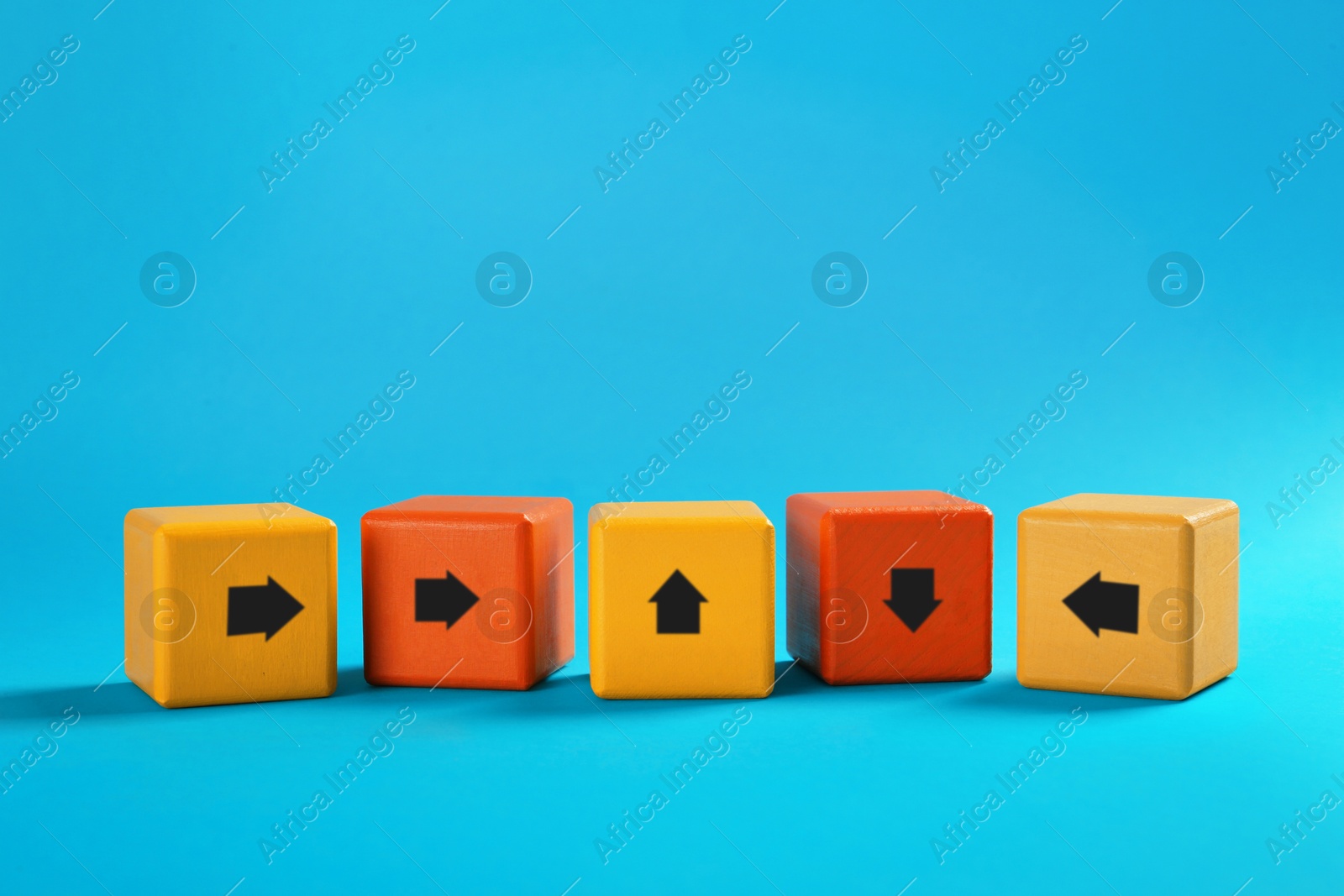 Image of Colorful cubes with arrows pointing in different directions on light blue background