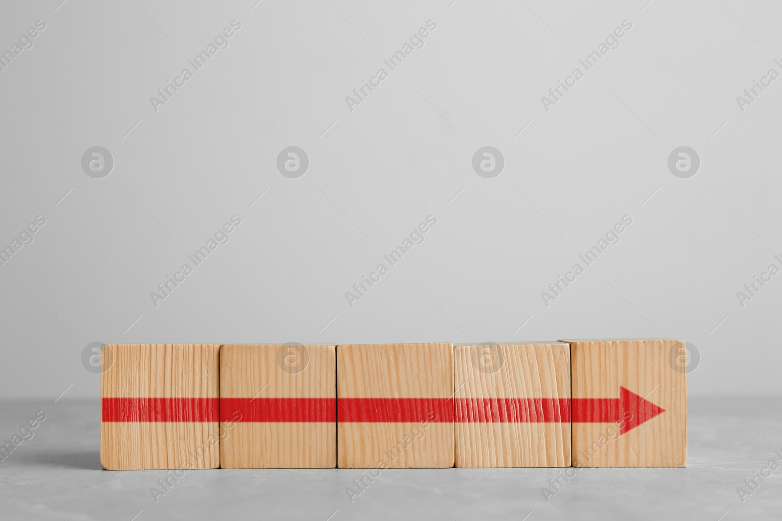 Image of Red arrow made of cubes on light background