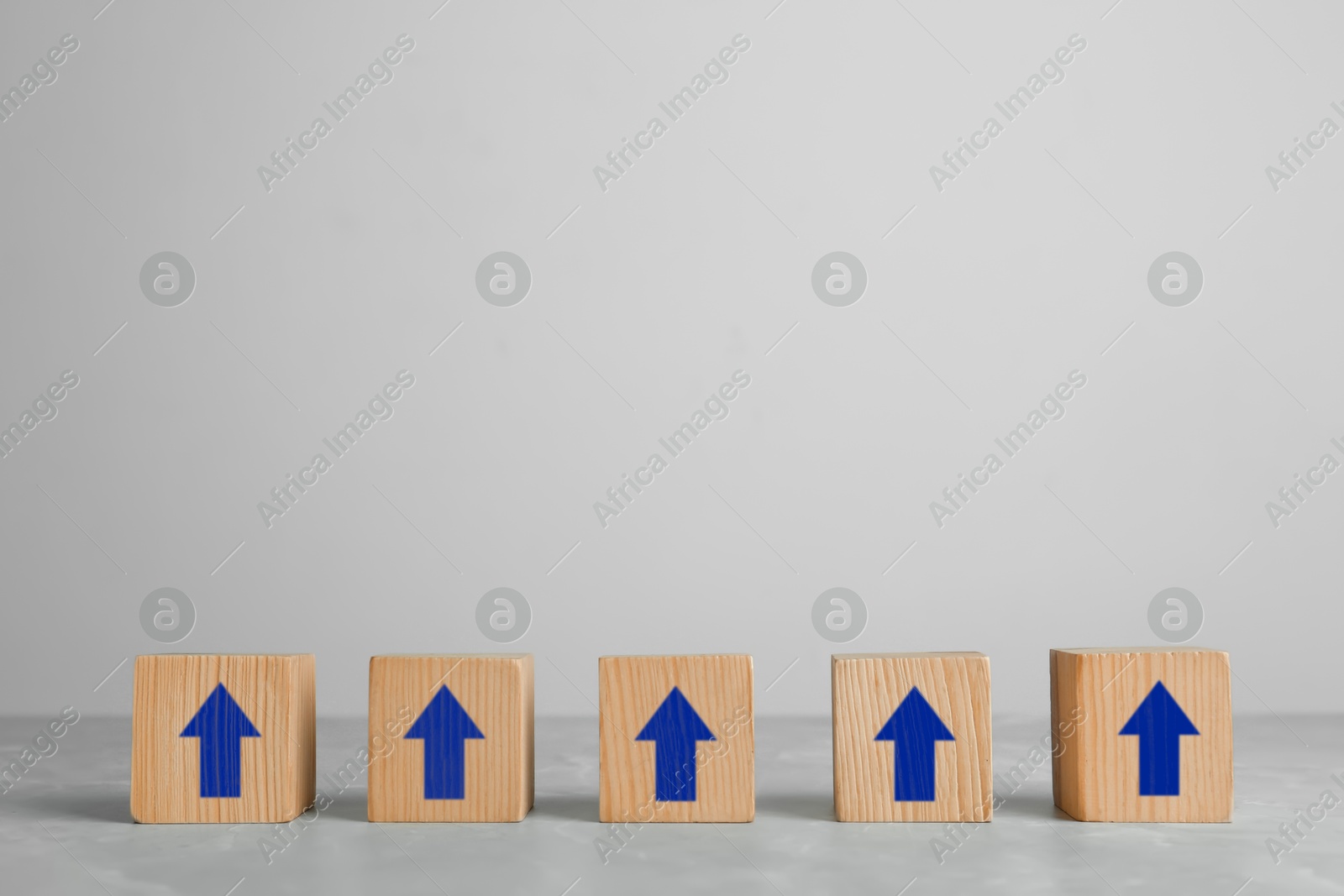 Image of Wooden cubes with blue arrows on light background