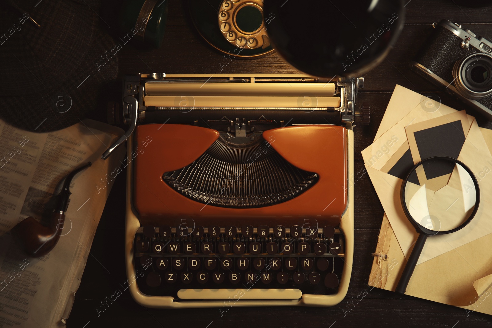 Image of Typewriter, magnifying glass and papers on detective's desk, flat lay