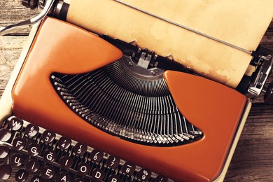 Image of Old vintage typewriter with paper on wooden table, top view