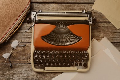 Image of Old vintage typewriter and sheets of paper on wooden table, top view