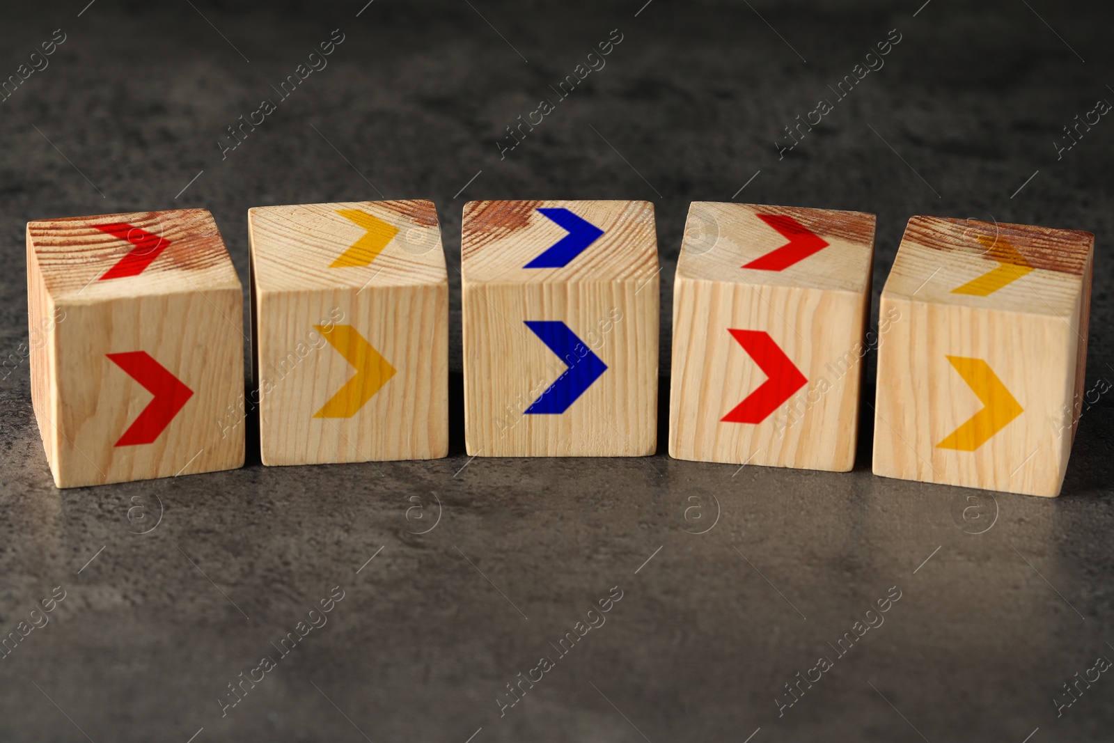 Image of Wooden cubes with colorful arrows on grey table