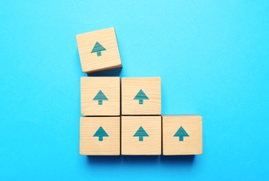 Image of Wooden cubes with arrows on light blue background, top view