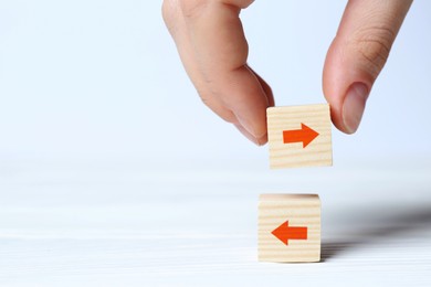 Image of Woman holding wooden cube with red arrow on white background, closeup. Space for text