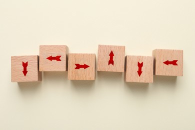 Image of Wooden cubes with red arrows on beige background, top view