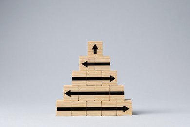 Image of Wooden cubes with black arrows on white table