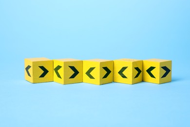 Image of Yellow cubes with black arrows on light blue background