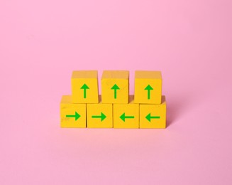 Image of Yellow cubes with green arrows on pink background