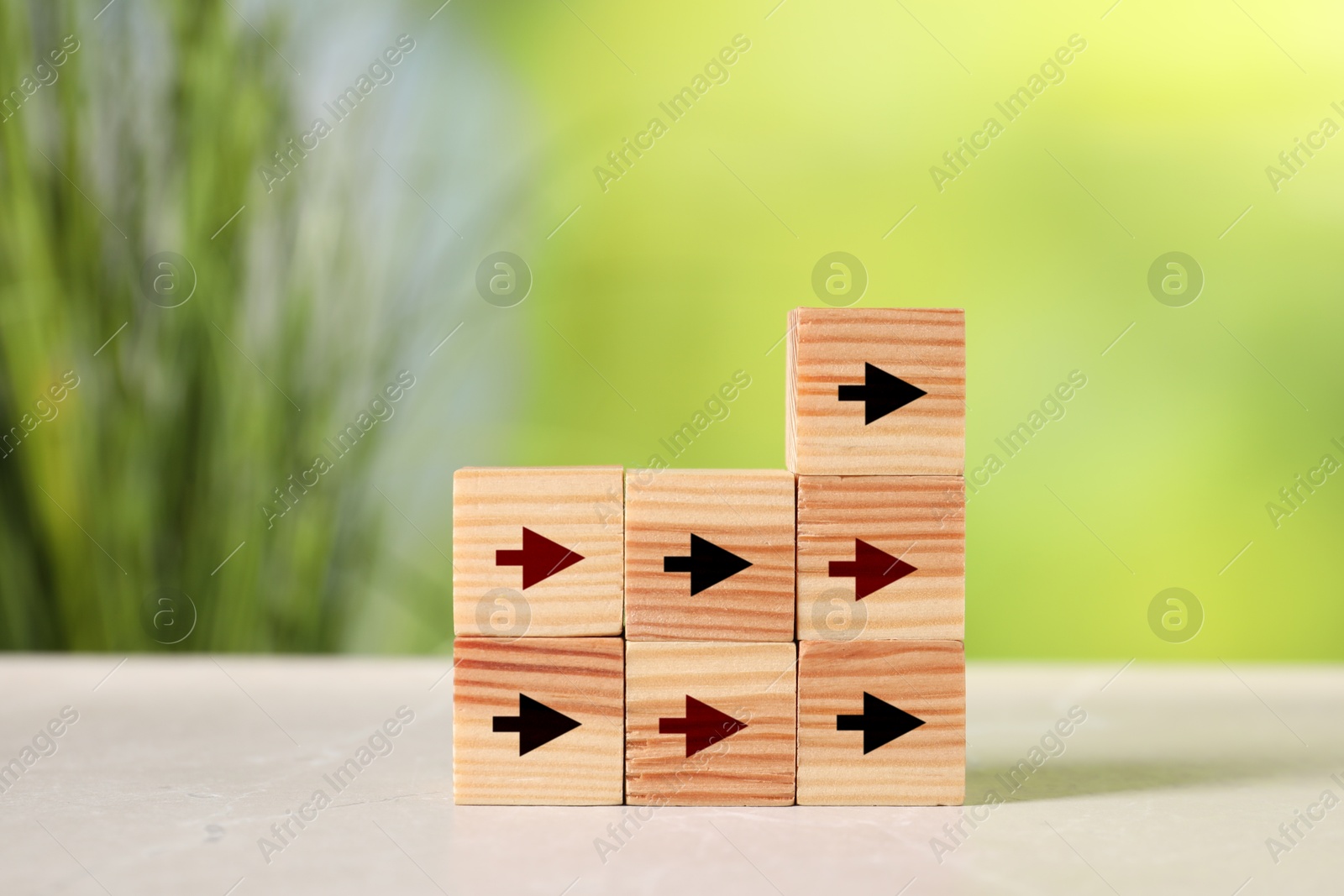 Image of Wooden cubes with black and red arrows on table against blurred background