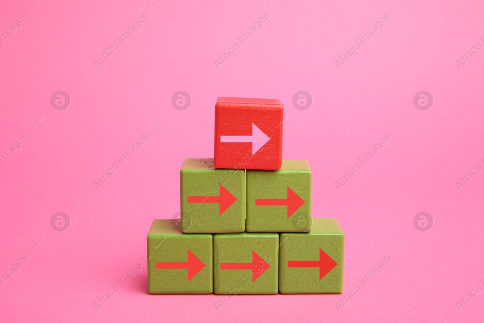 Image of Cubes with arrows and red one on top against pink background