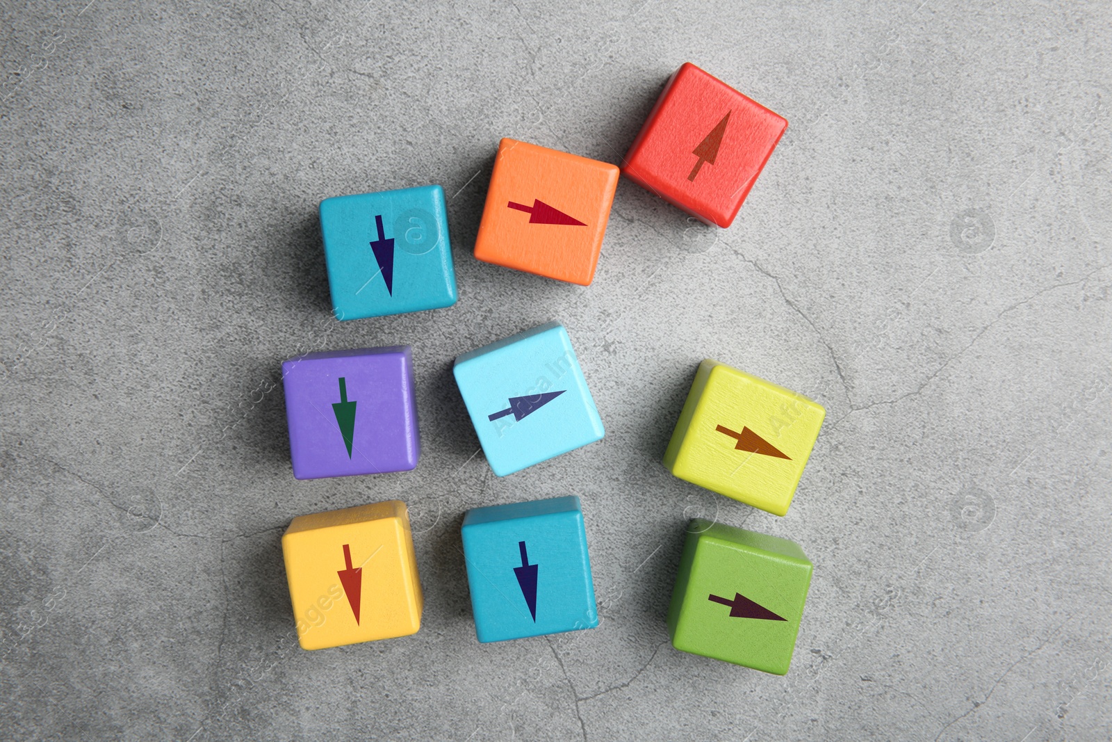 Image of Colorful cubes with arrows pointing in different directions on grey background, top view