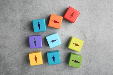 Image of Colorful cubes with arrows pointing in different directions on grey background, top view