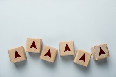 Image of Wooden cubes with arrow on light background, top view