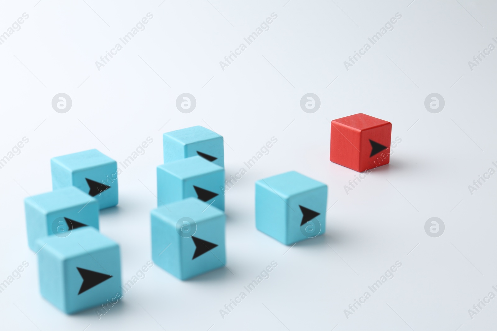 Image of Light blue cubes with arrows following after red one on white background