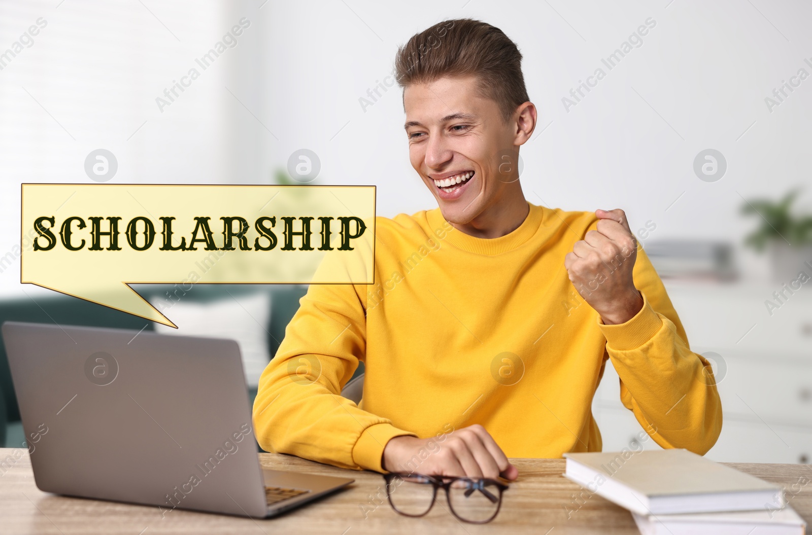 Image of Scholarship. Happy student with laptop at table indoors