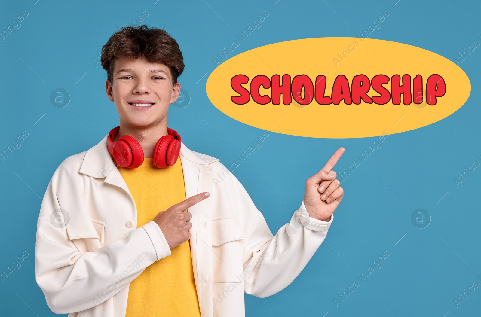 Image of Happy teenage boy with headphones pointing at word Scholarship on light blue background