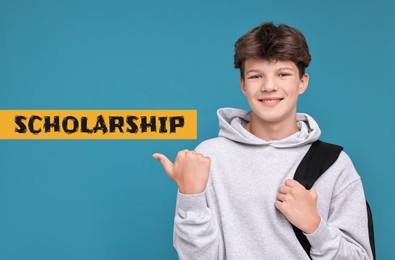 Image of Happy teenage boy with headphones pointing at word Scholarship on light blue background