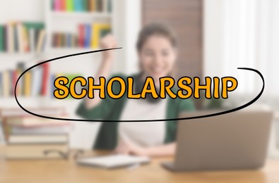 Image of Scholarship. Happy student with laptop at table, blurred view