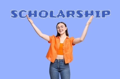 Image of Scholarship. Happy student holding word on violet blue background