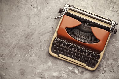 Image of Old vintage typewriter on grey textured table, top view. Space for text