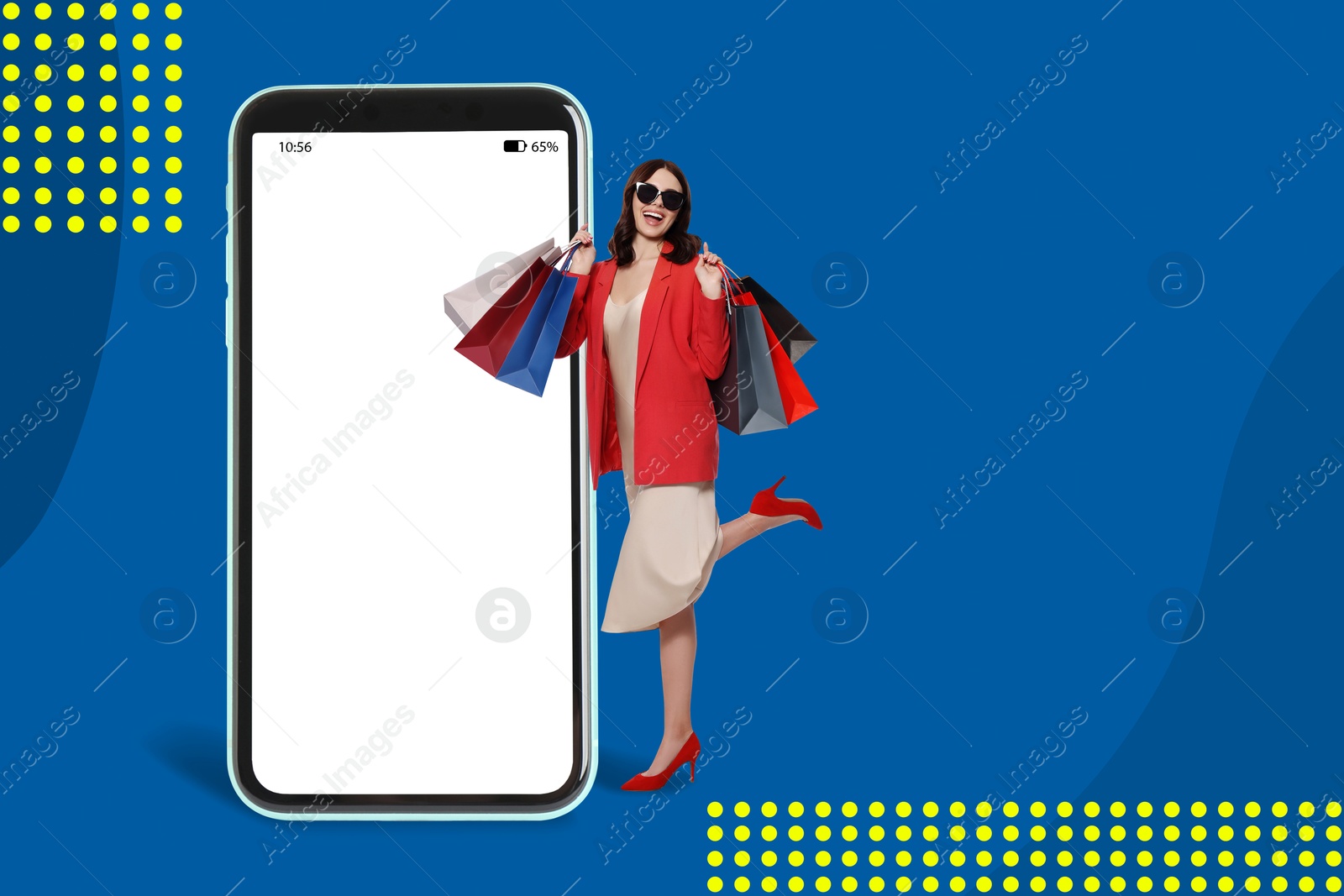 Image of Happy stylish woman with shopping bags near huge smartphone on blue background. Mockup with space for design