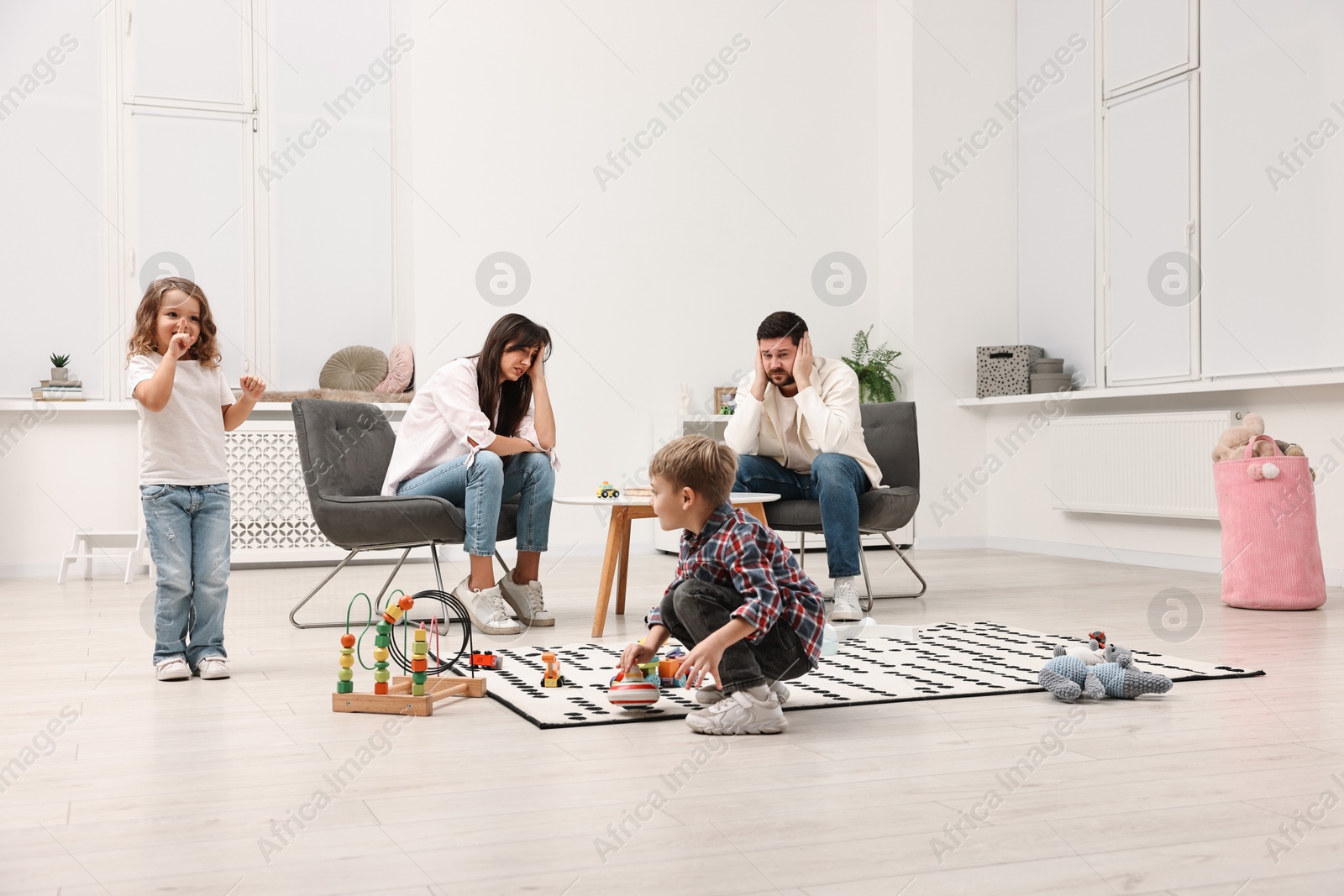 Photo of Hyperactive children playing and their overwhelmed parents at home