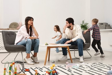 Photo of Hyperactive children playing and their overwhelmed parents at home