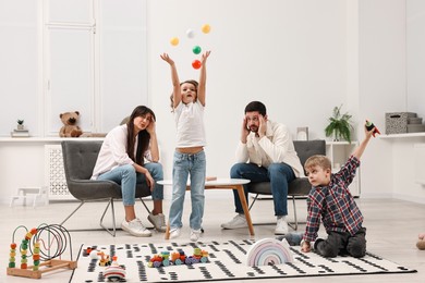 Photo of Hyperactive children playing and their overwhelmed parents at home