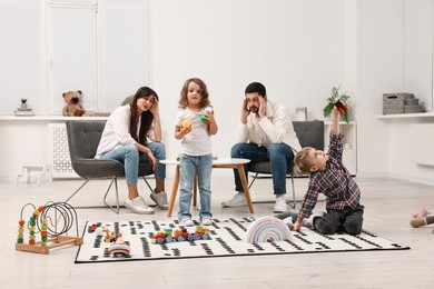 Photo of Hyperactive children playing and their overwhelmed parents at home