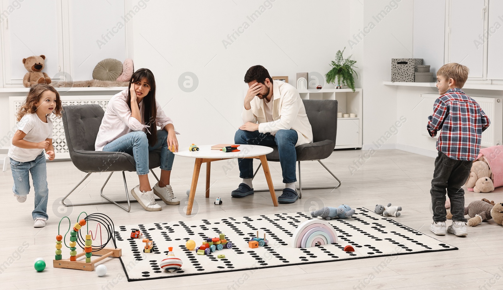 Photo of Hyperactive children playing and their overwhelmed parents at home