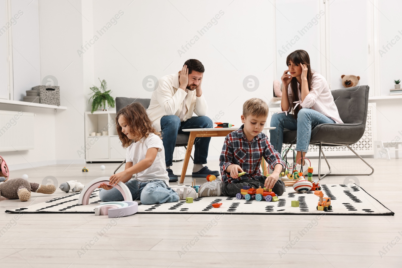 Photo of Hyperactive children playing and their overwhelmed parents at home