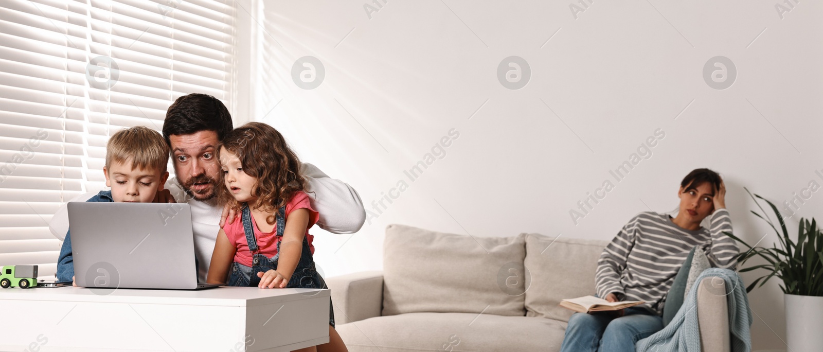 Photo of Father with children using laptop while their overwhelmed mother on sofa at home. Space for text