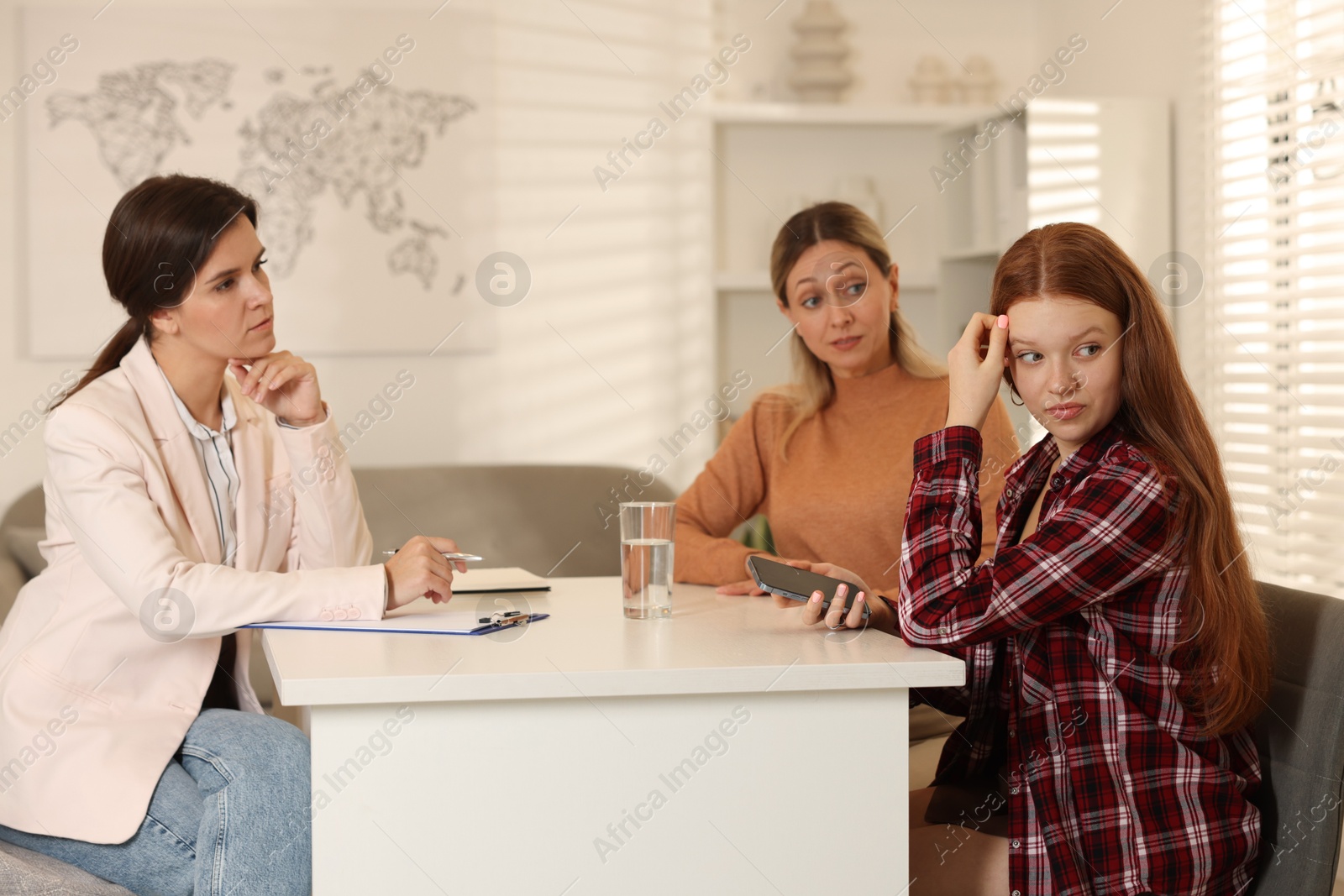 Photo of Difficult teenager. Mother and daughter having consultation with psychologist in office, selective focus