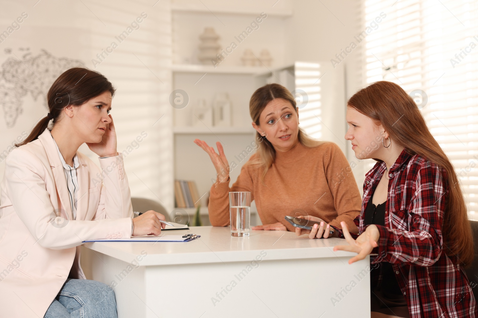 Photo of Difficult teenager. Mother and daughter having consultation with psychologist in office, selective focus