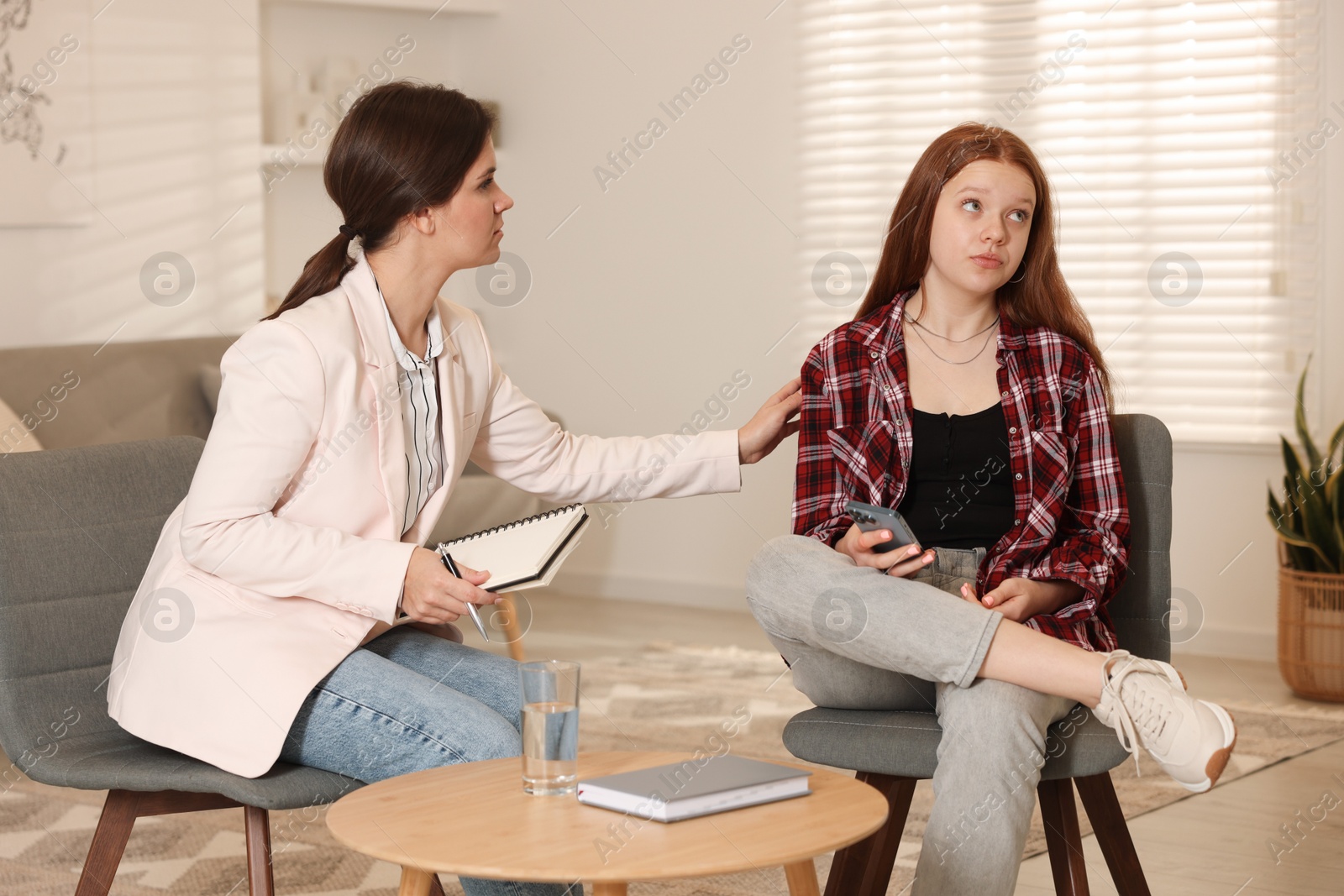 Photo of Psychologist working with difficult teenage girl in office