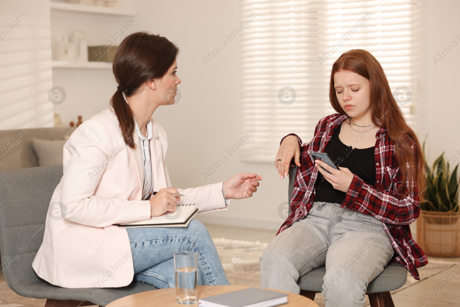 Photo of Psychologist working with difficult teenage girl in office