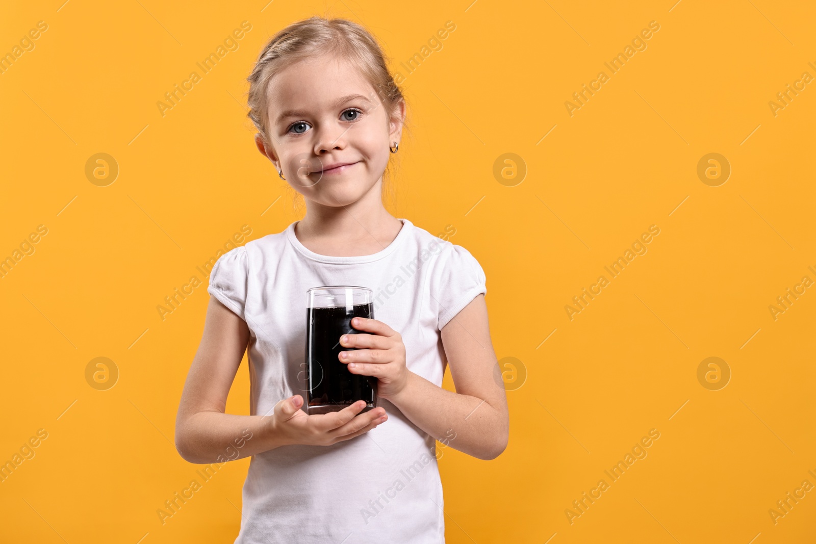 Photo of Girl with glass of refreshing soda drink on orange background, space for text