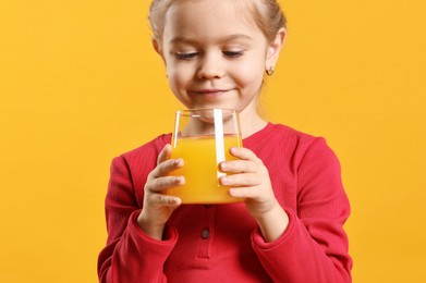 Photo of Girl with glass of juice on orange background. Refreshing drink